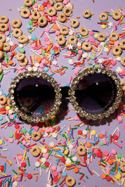 Decorative sunglasses with rhinestones on a colorful sprinkles and cereal background