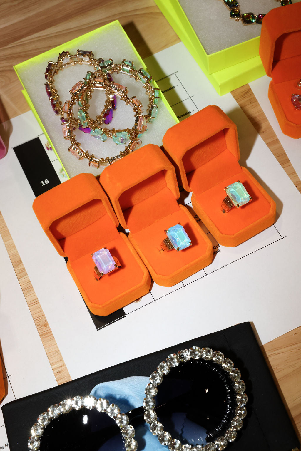Orange jewelry boxes with gemstone rings on a table