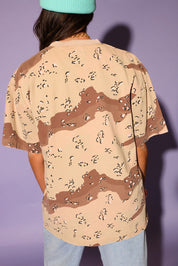Person wearing a camouflage-patterned shirt with a plain background, back view