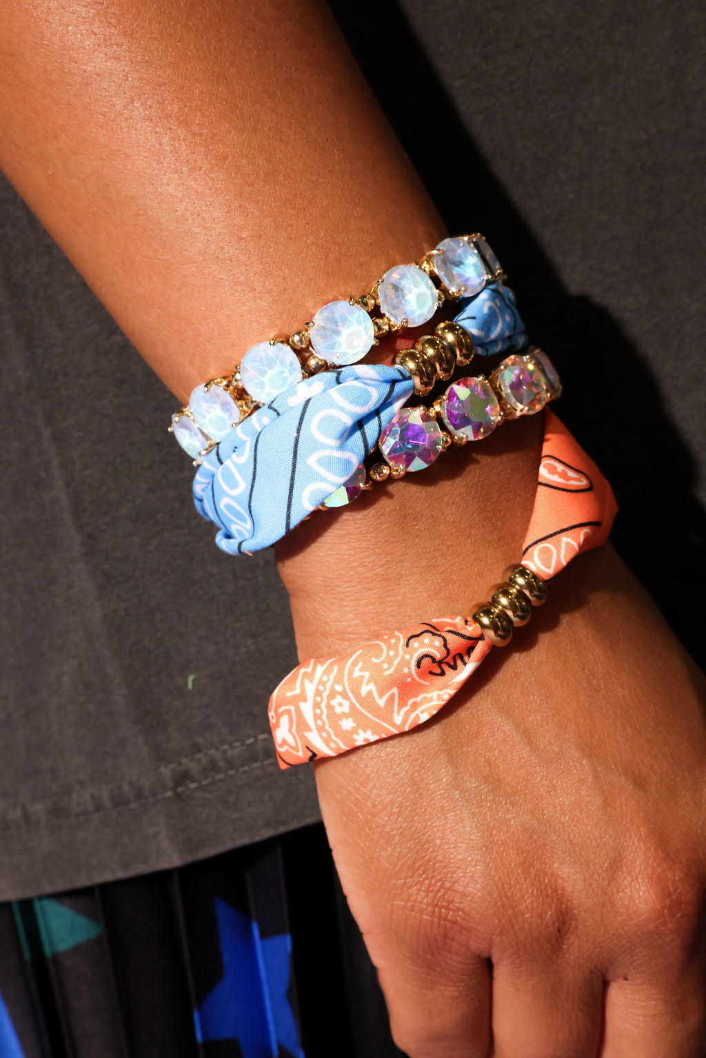 Close-up of a wrist wearing multiple colorful bracelets on a dark background