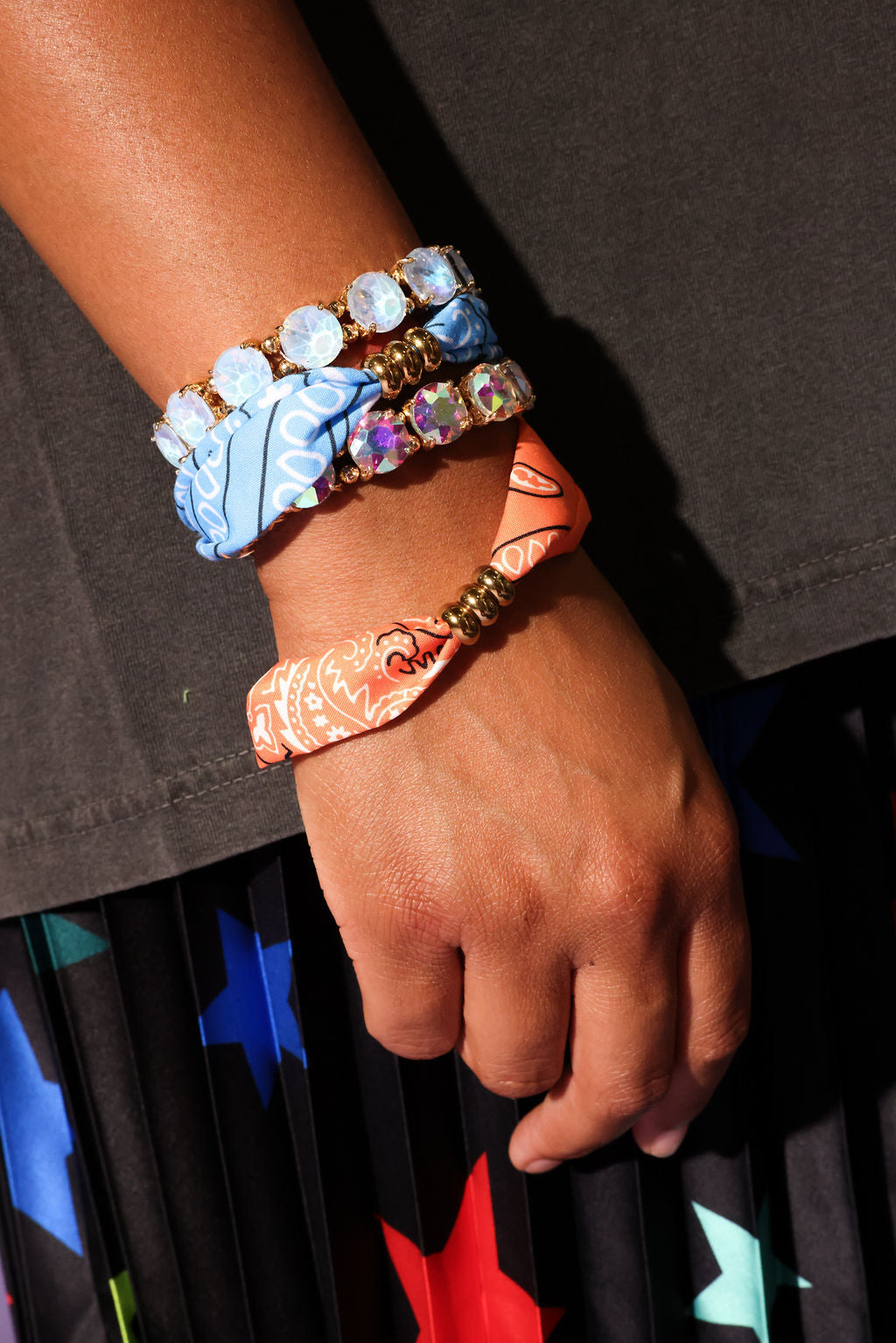 Close-up of a hand wearing colorful bracelets with a dark background