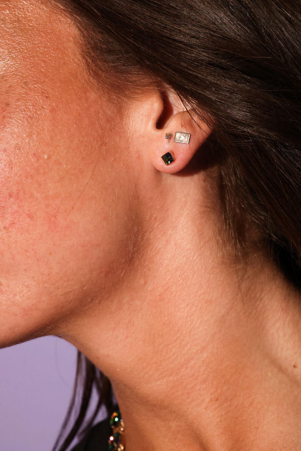 Close-up of an ear with earrings against a blurred background