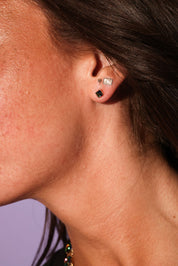 Close-up of an ear with earrings against a blurred background