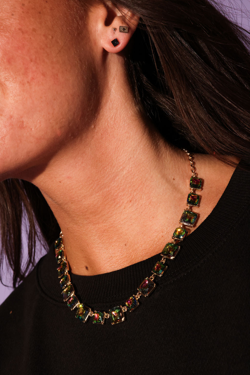 Close-up of a person wearing a colorful necklace and earrings