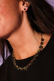 Close-up of a person wearing a colorful necklace and earrings