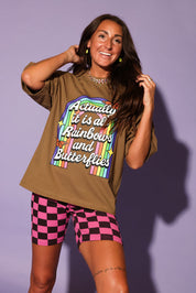 Woman wearing a graphic t-shirt with colorful text and checkered shorts against a purple background