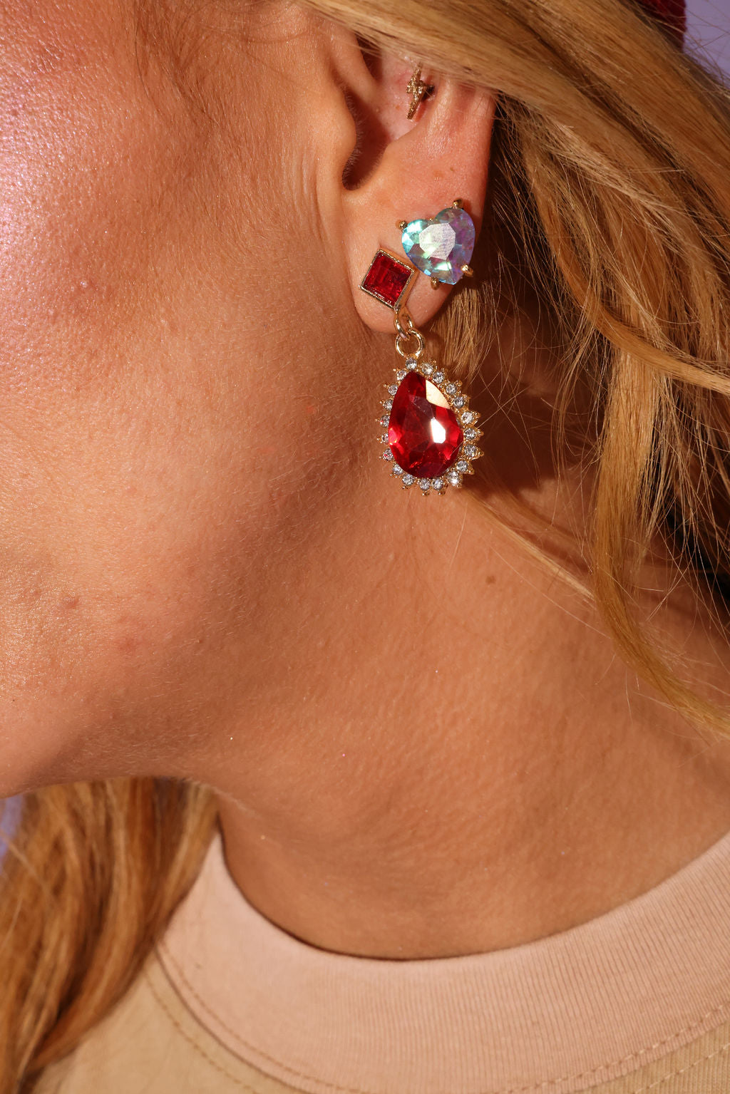 Close-up of a person wearing a red teardrop earring