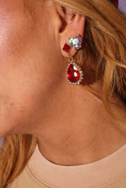 Close-up of a person wearing a red teardrop earring