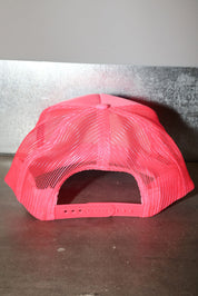 Pink mesh trucker hat on a metallic surface, back view