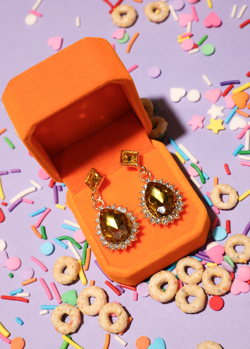 Jewelry box with diamond earrings on a colorful background
