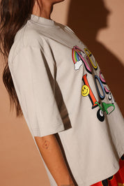 Beige shirt with colorful design on a plain background, side view