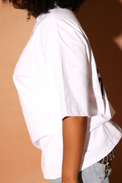 White shirt with jeans worn by a person on a brown background, side view