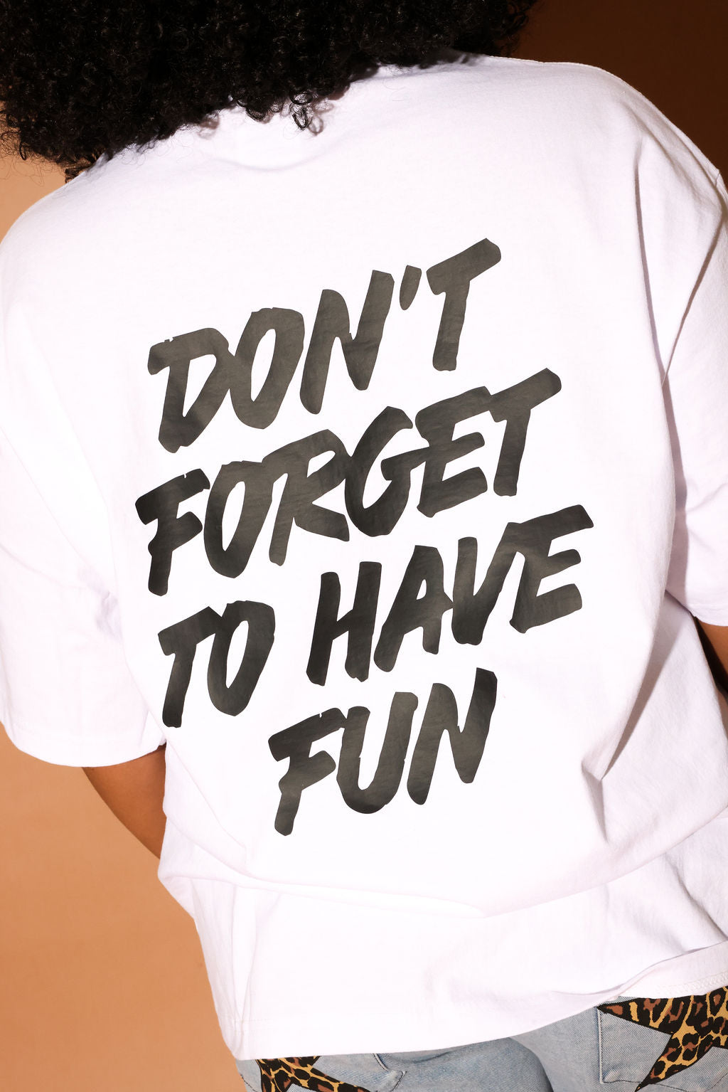 White t-shirt with 'Don't forget to have fun' text on the back