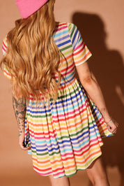 Woman wearing a colorful striped short dress and pink beanie against a brown background, back view
