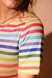 Close up of a woman wearing a colorful striped short dress focus on sleeve