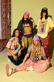 A group of four models wearing colorful outfits on a pale yellow background