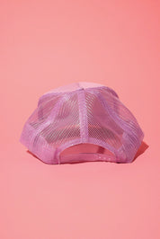 Back view of a lavender trucker hat on a pink background