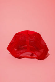 Back view of a red trucker hat on a pink background