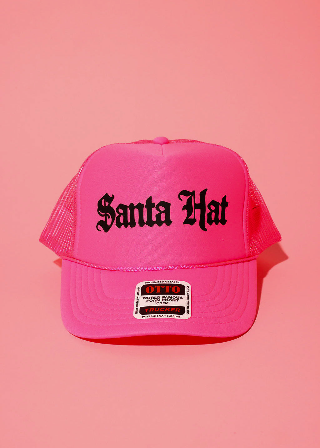 Neon pink trucker hat with black text that reads 'Santa Hat' on a pink background