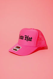 Side view of a neon pink trucker hat with black text that reads 'Santa Hat' on a pink background