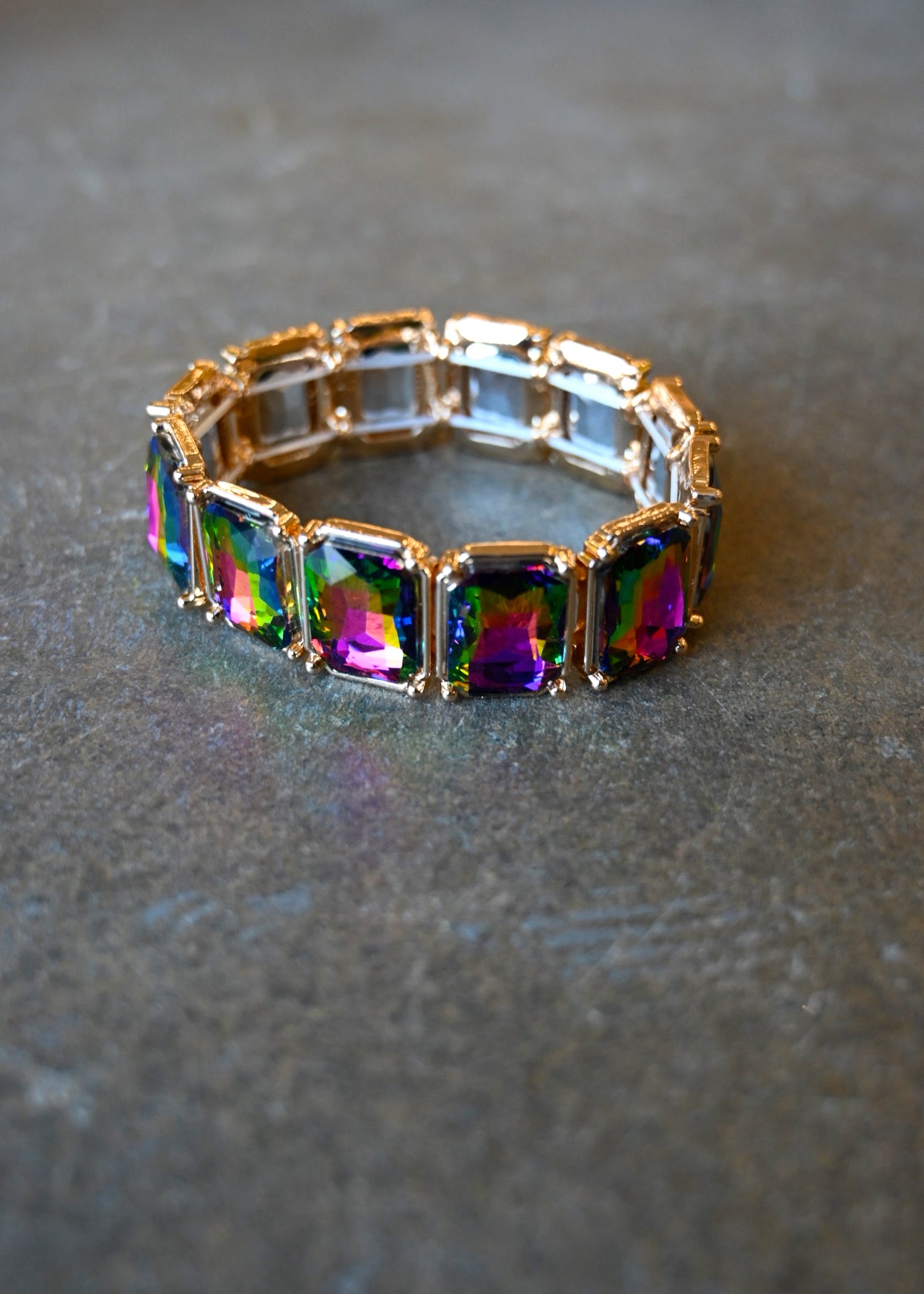 a multicolor jewel bracelet with gold platings on a dark background