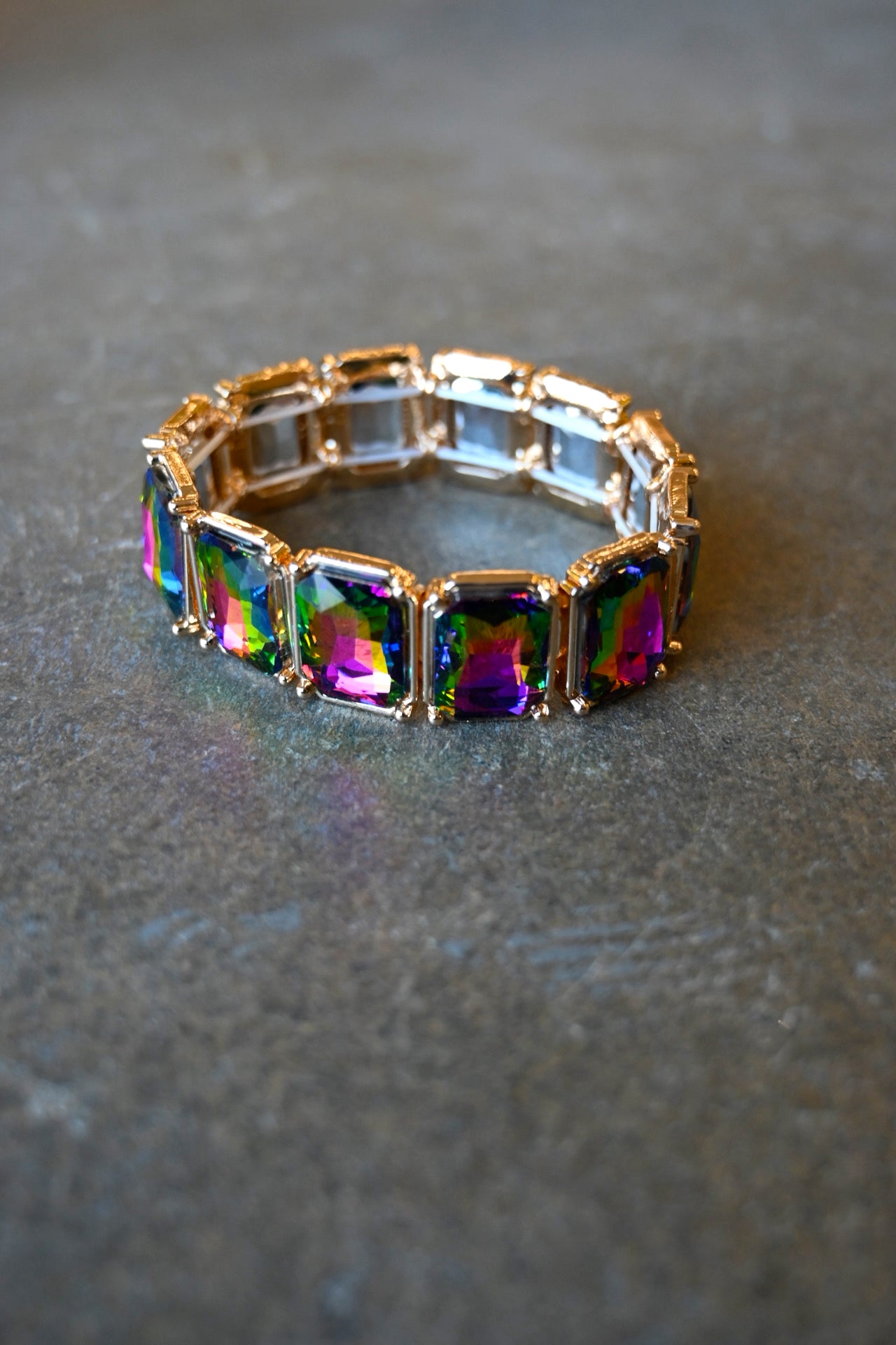 a multicolor jewel bracelet with gold platings on a dark background
