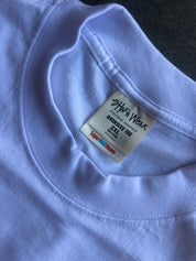 Close-up of a light lavender crewneck t-shirt showing the inner neck label which reads 'SHAKA WEAR' and 'OVERSIZE TEE 2XL'.