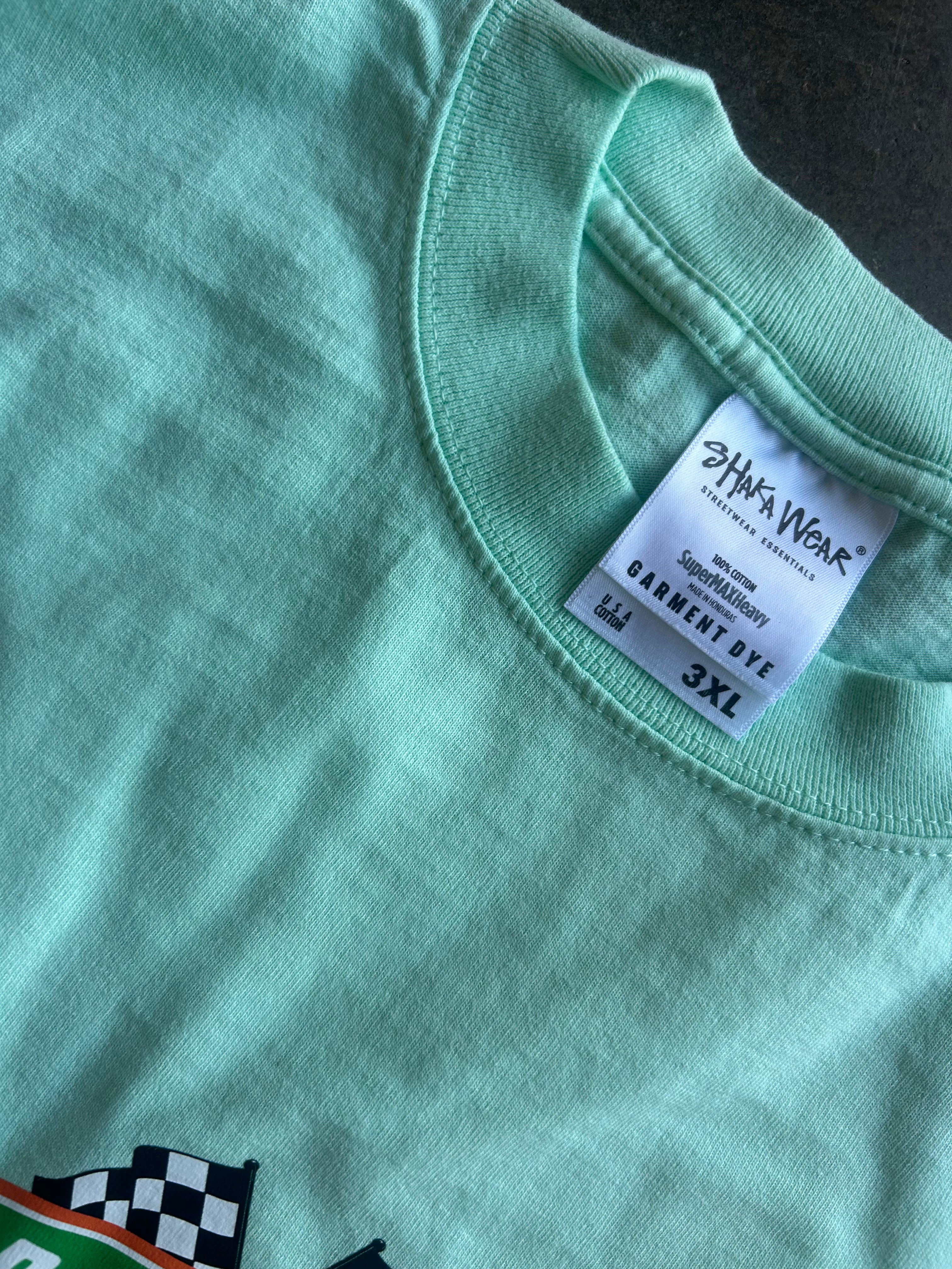Close-up of a mint green t-shirt showing the inner neck label which reads 'Shady Wear' and 'Garment Dye 3XL'.