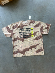 Camo graphic tee with WIERD Alien 3 times on a concrete surface