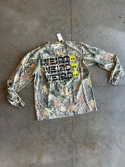 Long sleeve camo shirt with Weird and a alien face 3x on a concrete surface