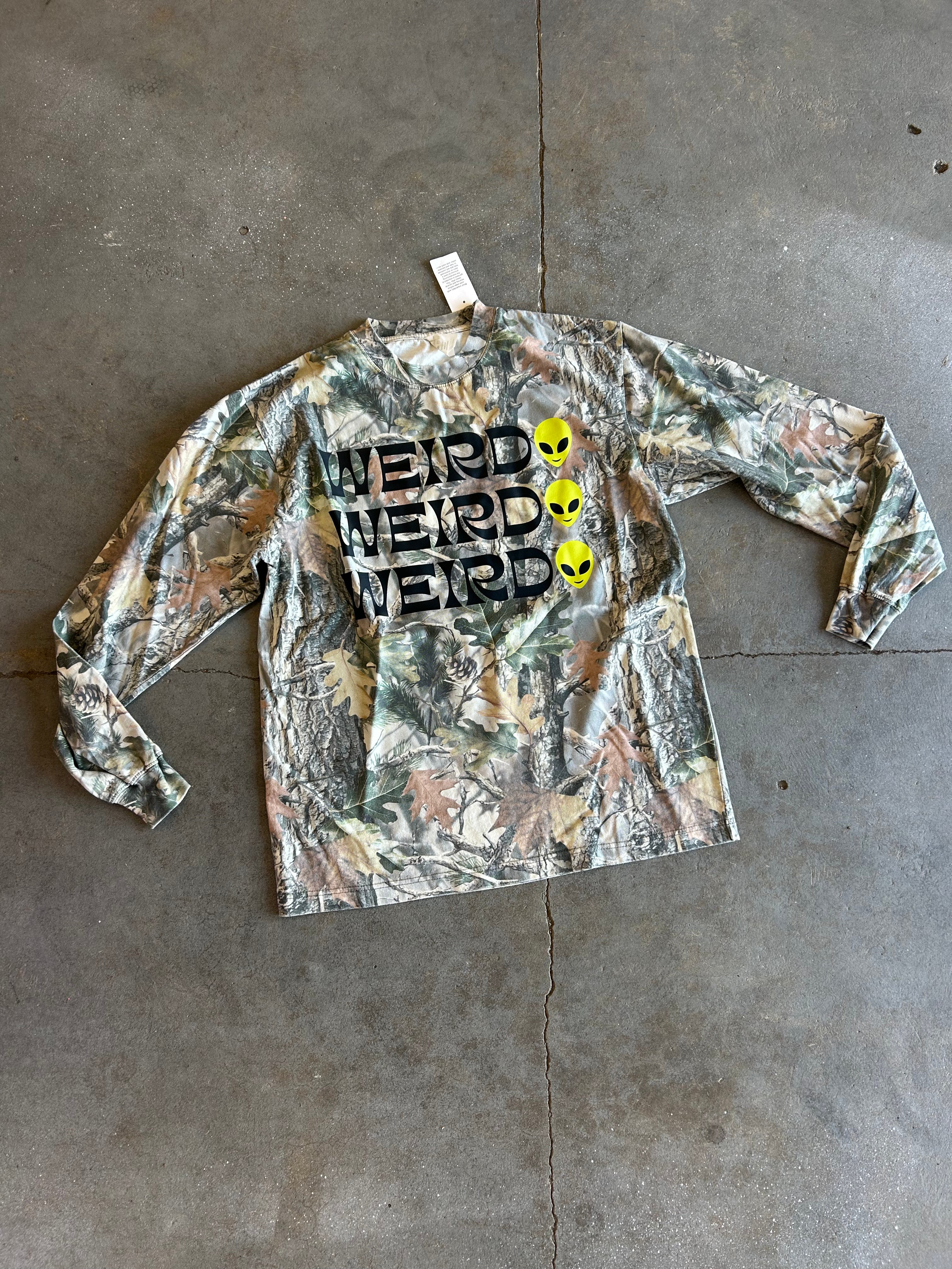 Long sleeve camo shirt with Weird and a alien face 3x on a concrete surface