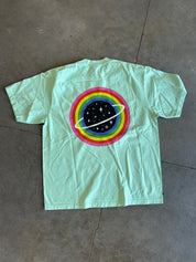 Planet graphic on the back of a seafoam green shirt on a concrete surface