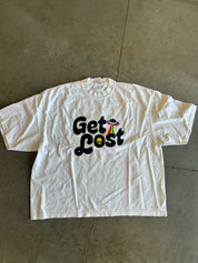 Get Lost graphic on a ivory tee on a concrete surface