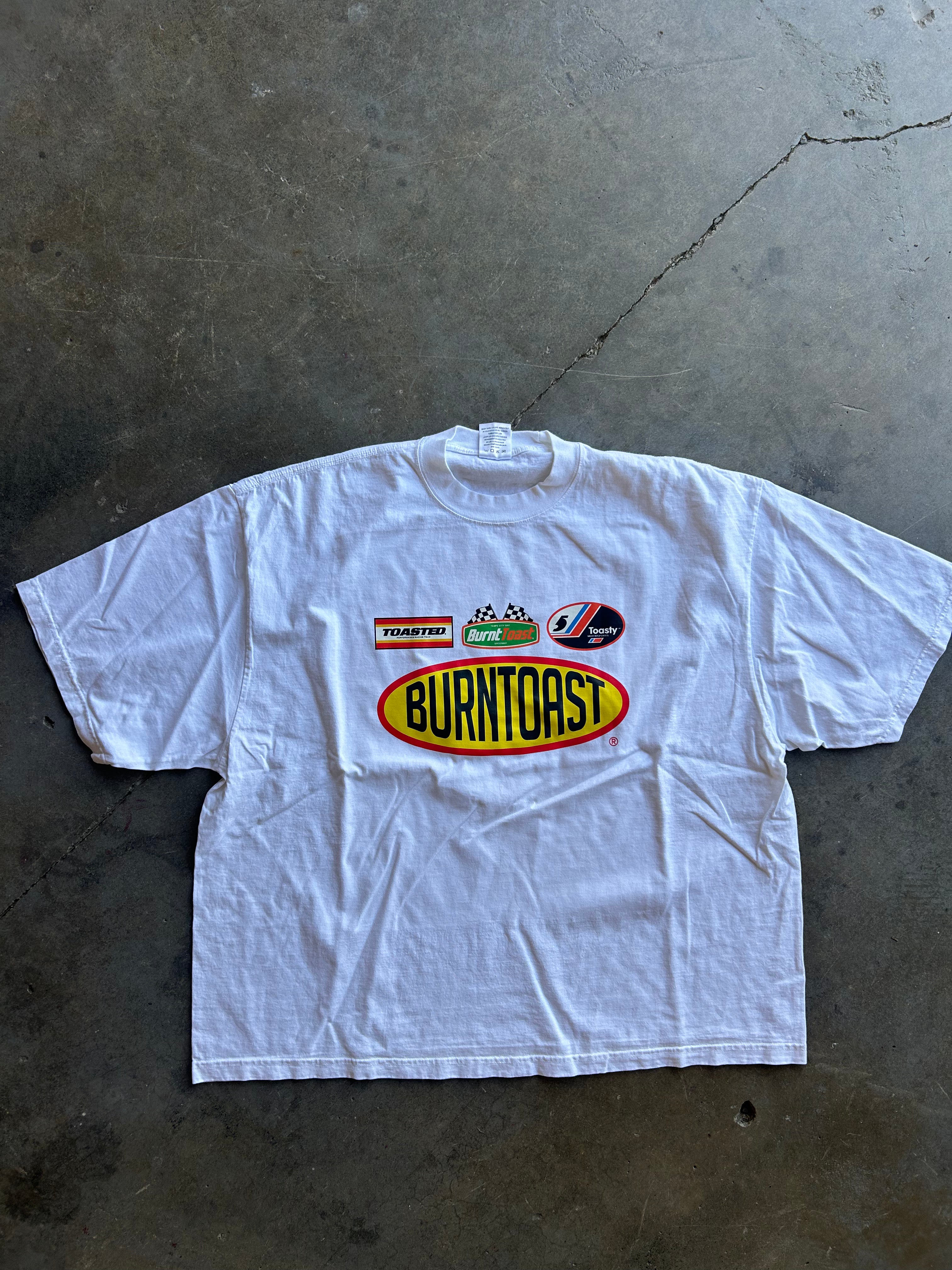 Burnt Toast logos on a white shirt on a concrete surface 