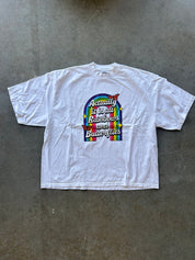 White shirt with rainbow graphic and text on a concrete surface