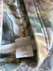 Close-up of a camouflage-patterned garment tag reading LARGE, with visible cotton fabric and a small GILDAN logo on the label.