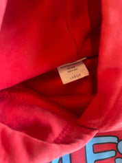 Close-up of a red hooded sweatshirt interior showing a sewn-on size tag labeled LARGE.