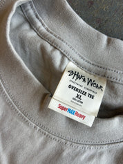Close-up of the inside collar of a light gray oversized cotton t-shirt, showing a white brand label for 'SHIWA WEAR' and 'SuperMAX Heavy'.