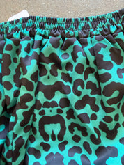 Close-up of a garment with an elastic waistband and a bold green and black leopard print pattern