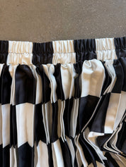 Black and white checkered pleated fabric with an elasticized top band, shown in a close-up view