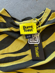 Close-up of a yellow and black striped ribbed knit garment with a visible Burnt Toast tag and size label