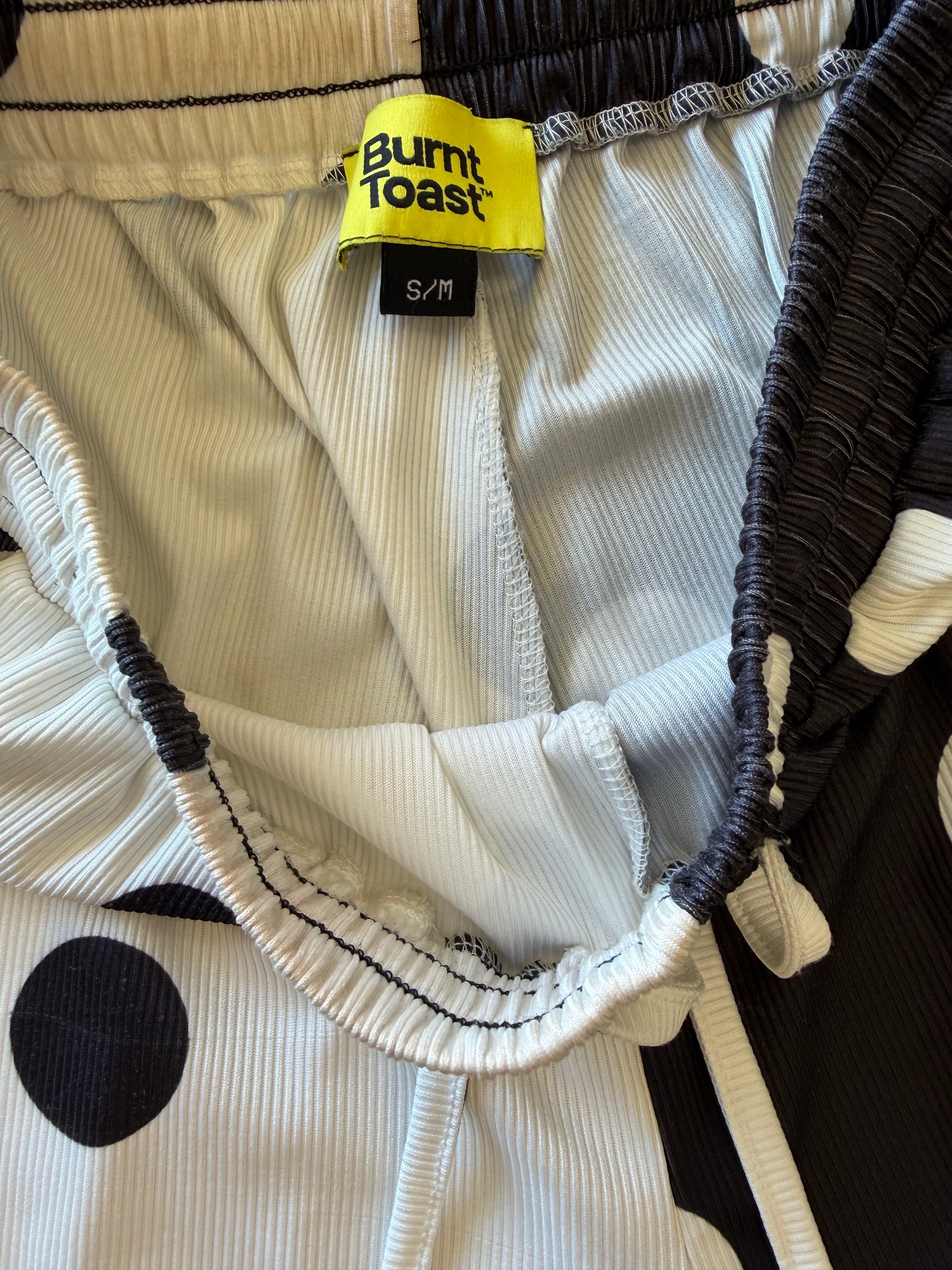 Close-up of a Burnt Toast garment showing the interior waistband, drawstring, and a yellow brand label reading S/M