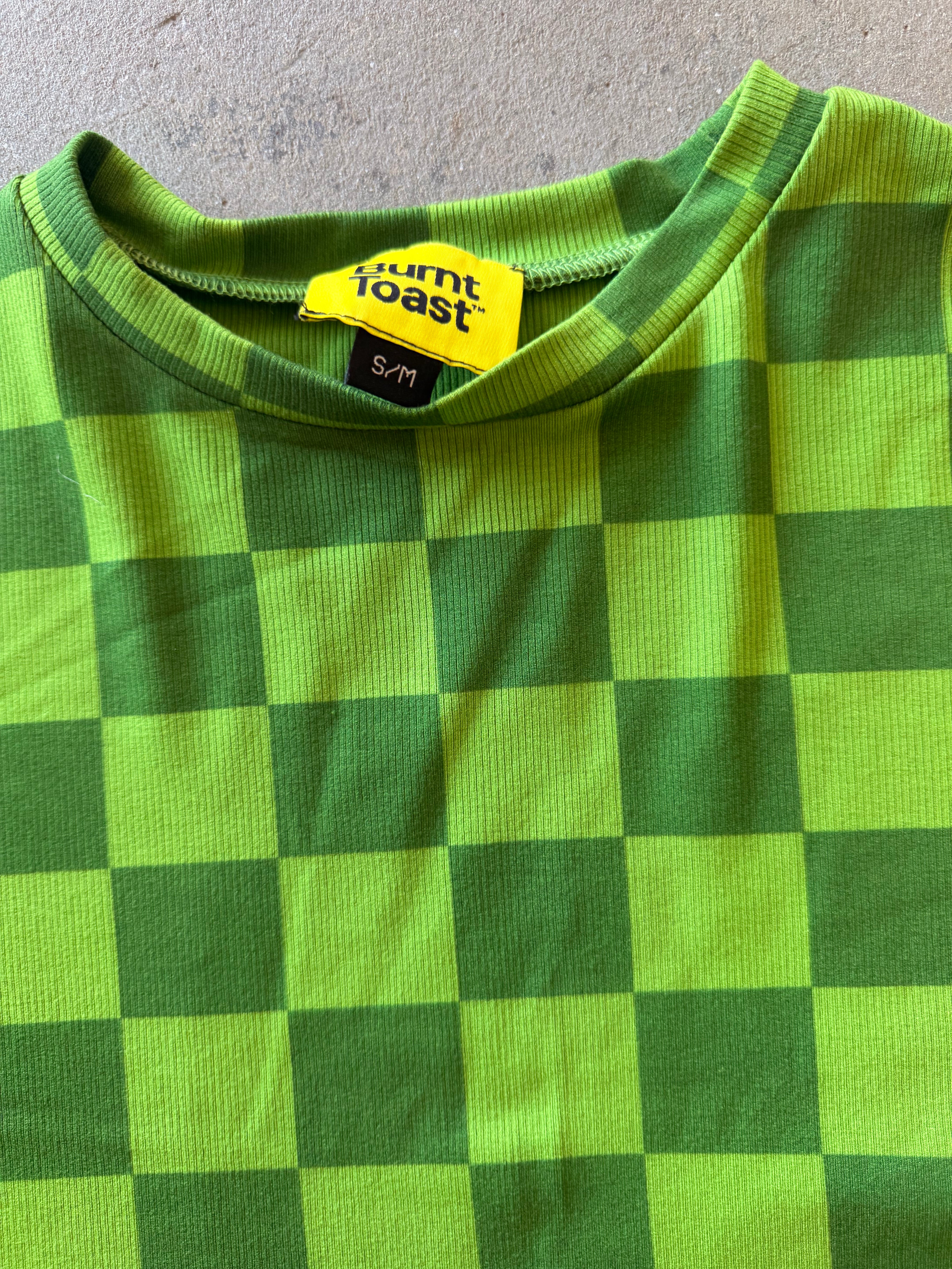 Close-up of a green and yellow checkerboard patterned shirt with a visible Burnt Toast brand label