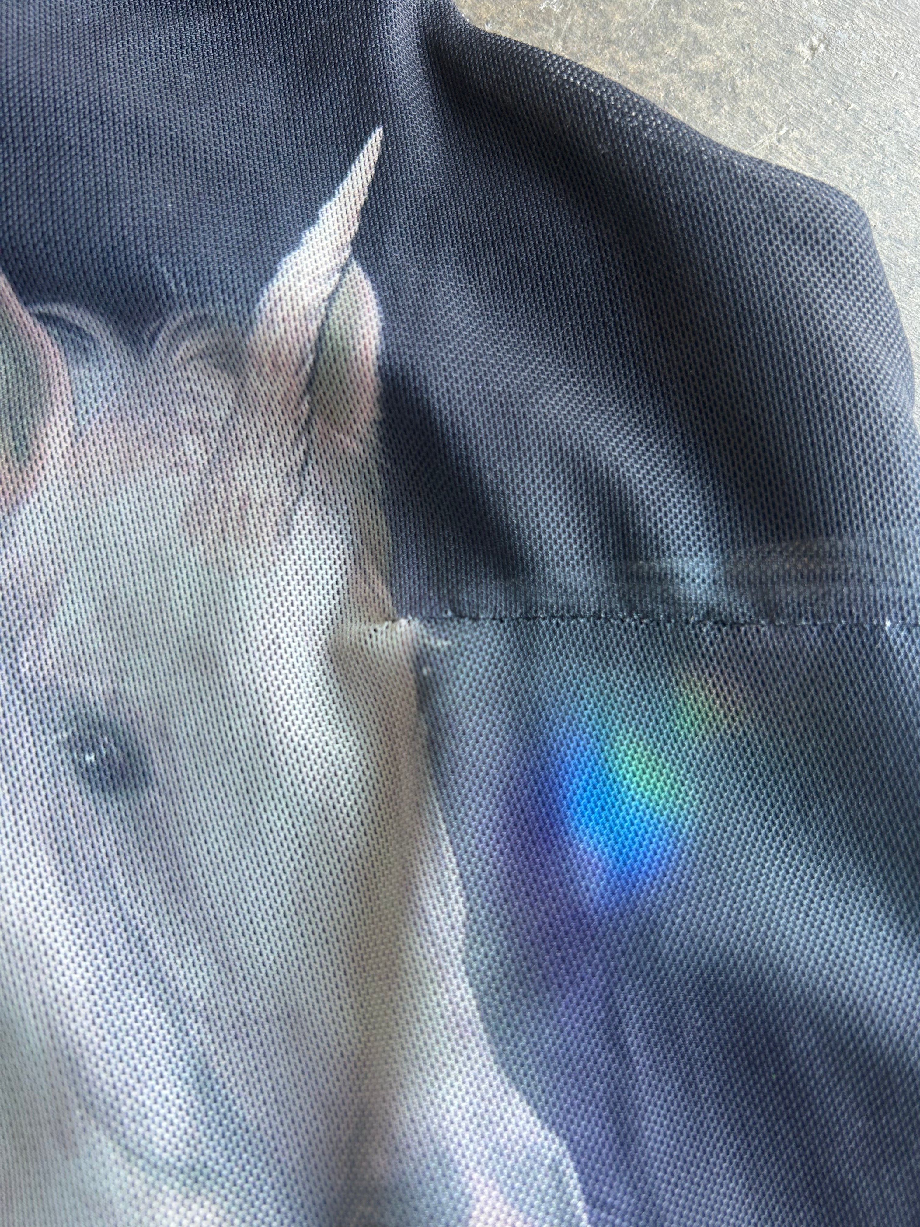 Close up of hem on mesh tank on a concrete surface
