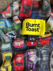 Close-up of a Burnt Toast shirt collar featuring a colorful car print and a bright yellow brand label