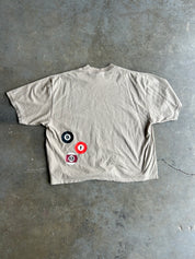 Back of beige tshirt with billiard balls, flat lay on a concrete floor