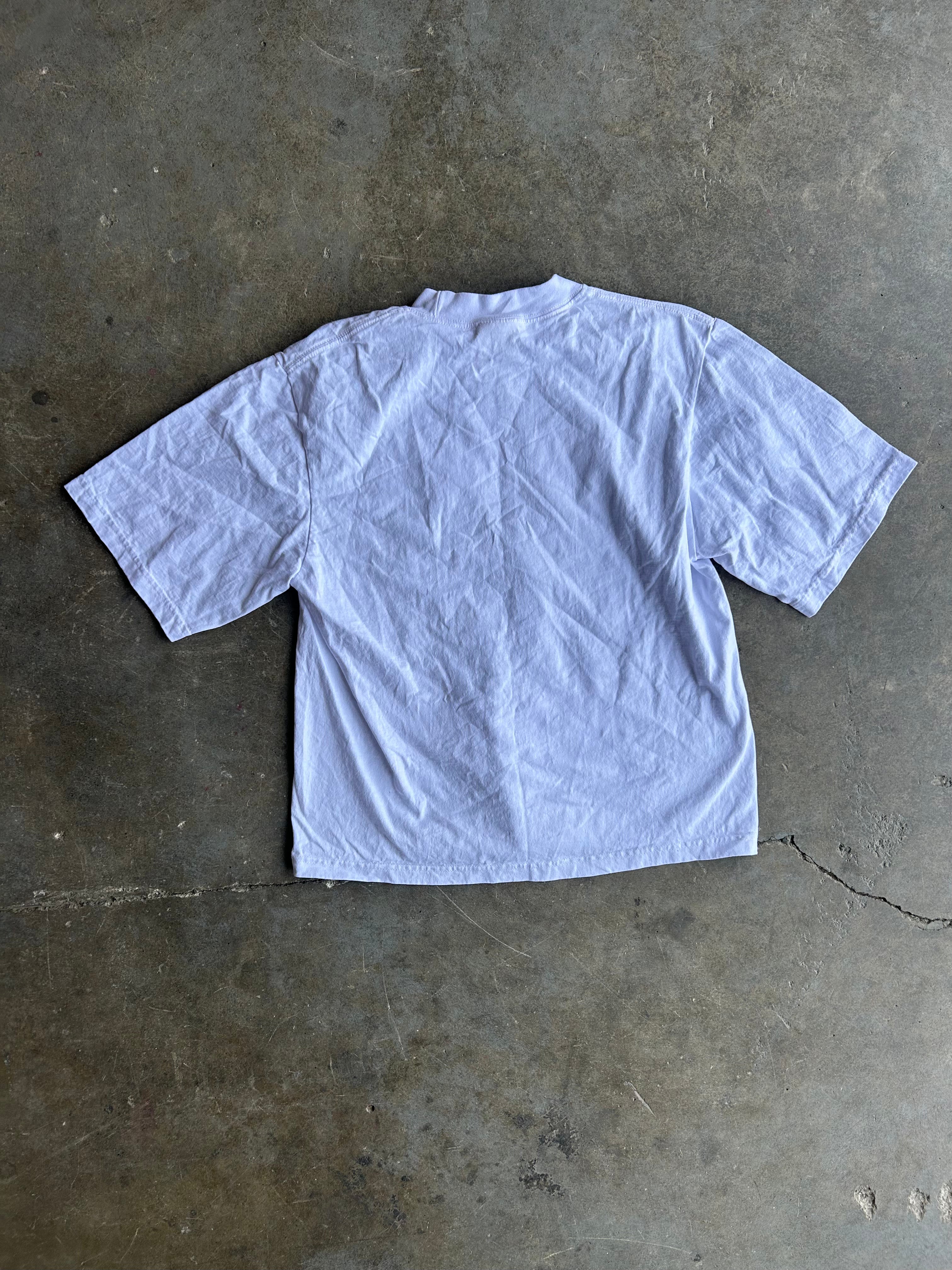 Back of a white tee shirt on a concrete surface