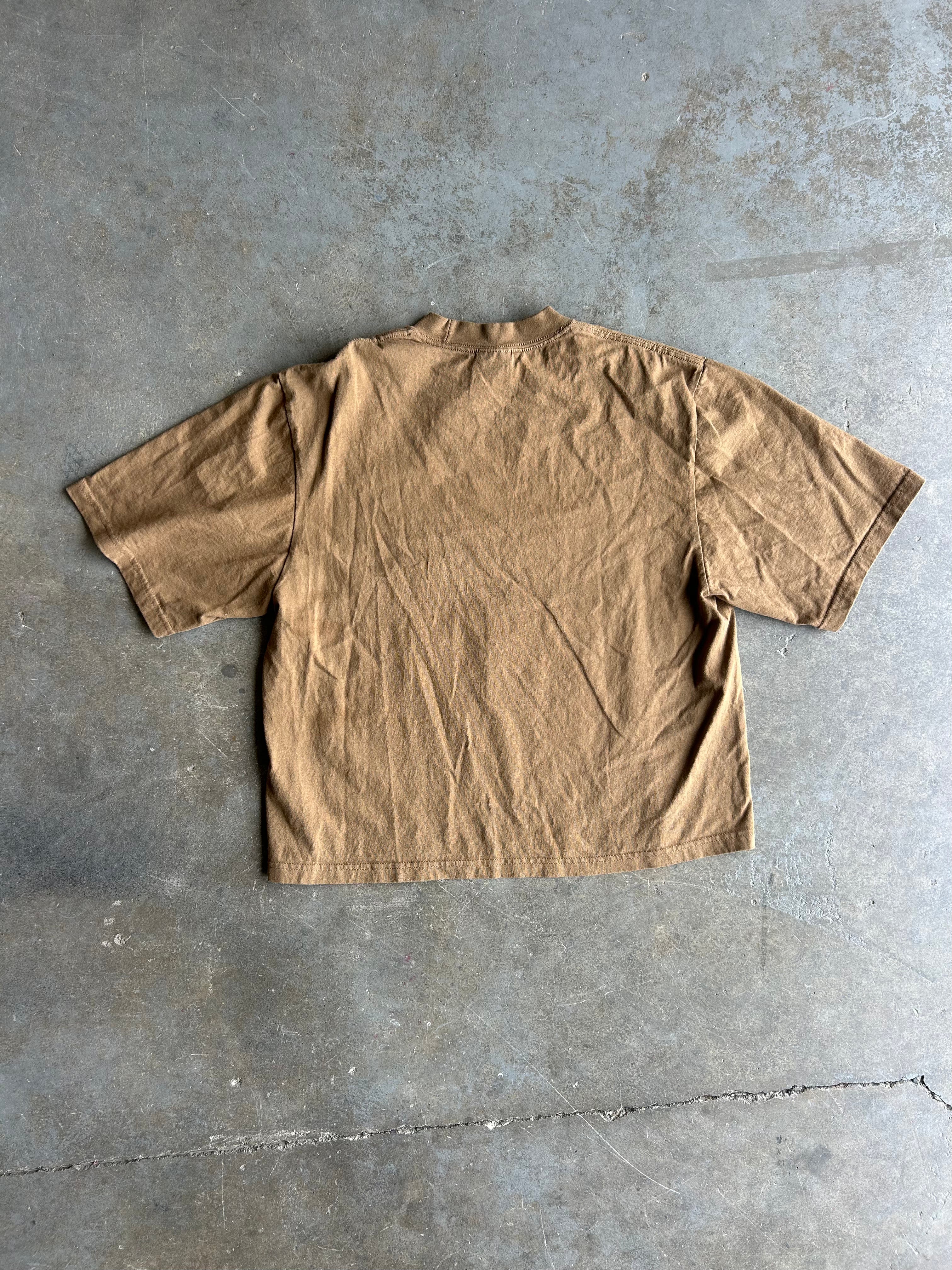 Back view of a brown short sleeve tee on a concrete surface