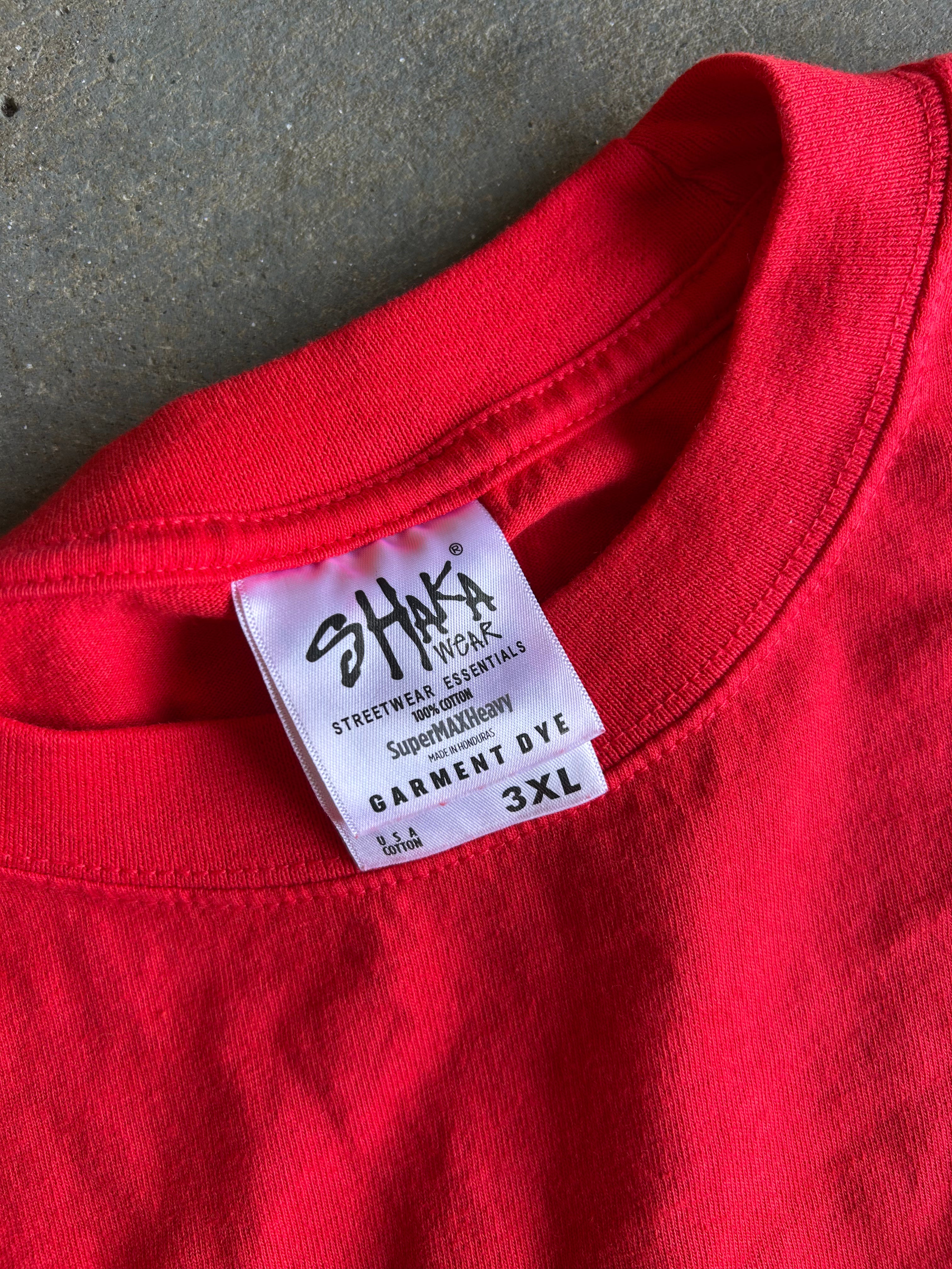 A close-up of a bright red crewneck sweatshirt showing the inner collar label which reads 'SHAKI WORK' and 'GARMENT BYE 3XL'.