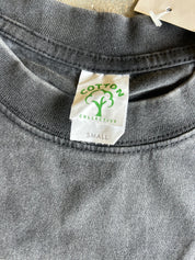 Close-up of a dark gray heather crewneck t-shirt showing the inner neck label which reads 'COTTON COLLECTIVE' with a green tree logo and 'SMALL' printed below.